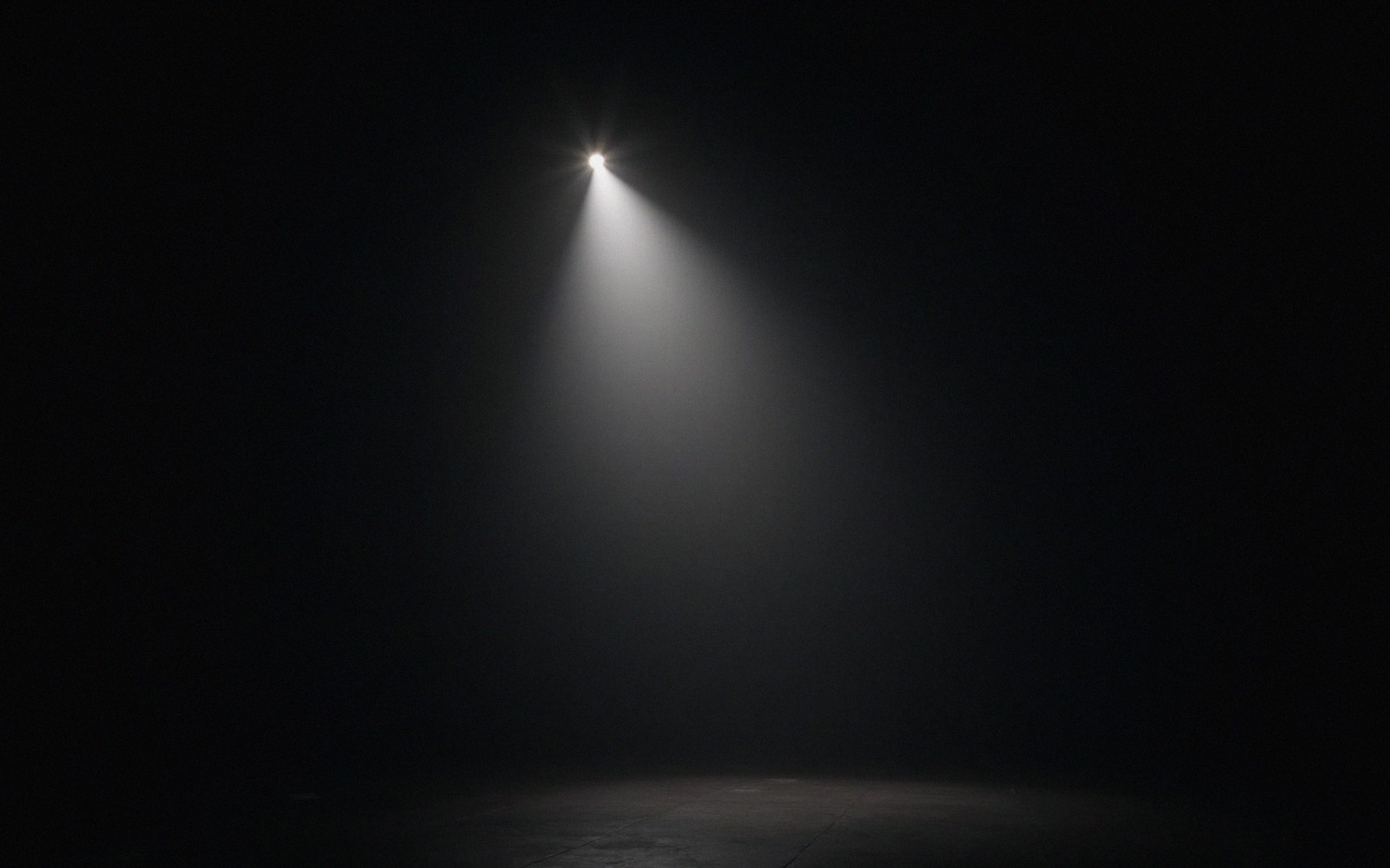 A blown-out stage light glowing against black, high contrast